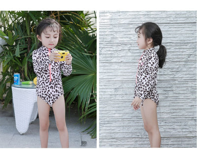 Child's long-sleeve leopard print swimsuit with a coral zipper and a matching swim cap on a white background. - Image 15