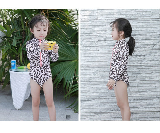 Child's long-sleeve leopard print swimsuit with a coral zipper and a matching swim cap on a white background. - Image 15