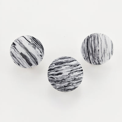 Black and white marbled EVA foam ball, a pet toy, on a white background with blurred flowers. - Image 6