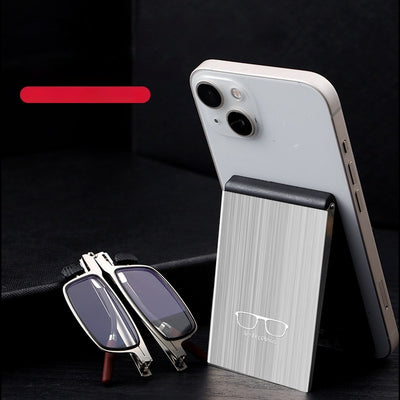 Foldable blue light blocking glasses with silver frames in a black case, shown on a smartphone.