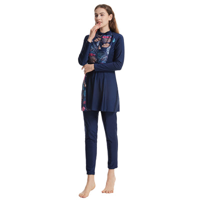 Woman in a navy blue quick-drying conservative swimwear set with a tropical leaf print tunic and matching swim cap. - Image 2