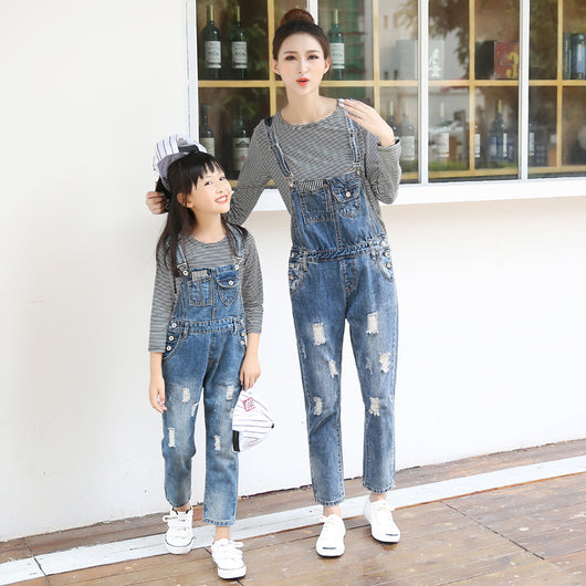 Mother and daughter wearing matching distressed denim overalls over black and white striped long-sleeve shirts. - Image 7