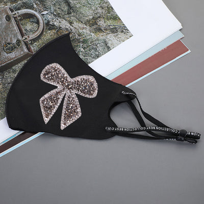 Black ear-mounted mask with a sparkling rhinestone bow pattern, featuring adjustable ear loops. - Image 20