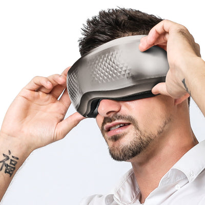 Man wearing a gray full automatic wireless eye massager with a textured geometric pattern on a white background. - Image 2
