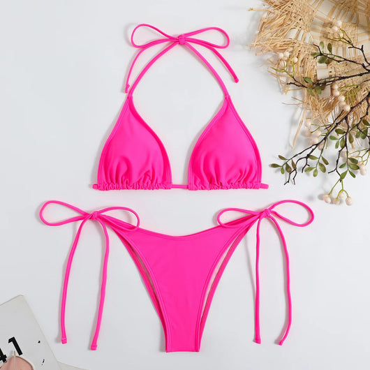 Neon yellow halter bikini with triangle top and tie-side bottoms, displayed on a light wood surface. - Image 9