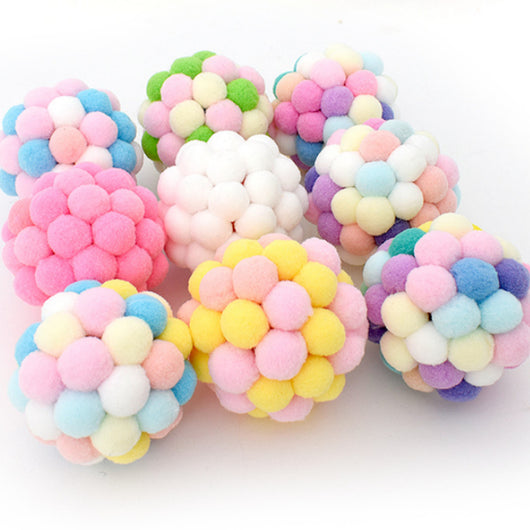 Colorful cat toy ball made of soft, pastel-colored pom-poms, including yellow, pink, purple, green, and blue.