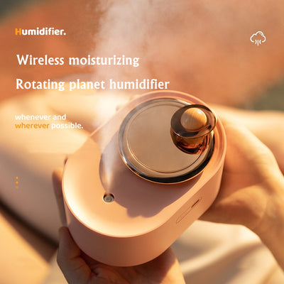 White USB rechargeable mini humidifier with a rose gold top accent and a wooden planet decoration. - Image 8