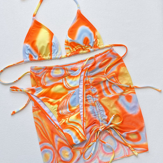 Women's three-piece swimsuit with orange, yellow, and blue abstract swirl pattern. Includes a triangle bikini top, tie-side bottom, and matching ruched sarong s - Image 4