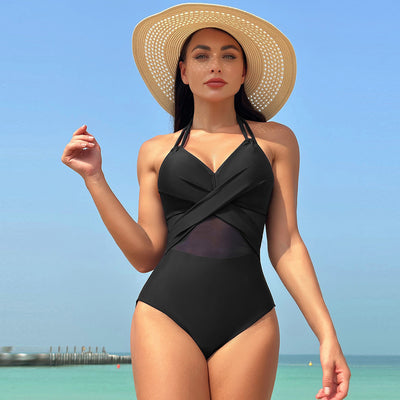 Woman in a green halter-neck one-piece swimsuit with cross-strap design and mesh cutouts, on a beach. - Image 26