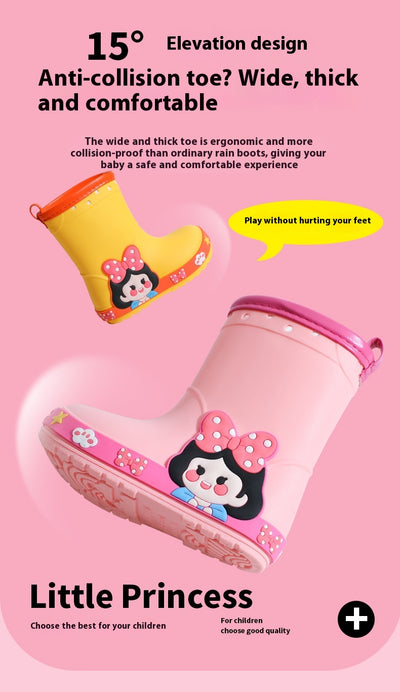 Bright yellow children's rain boots with a green cartoon dinosaur design and orange trim, held by hands. - Image 24
