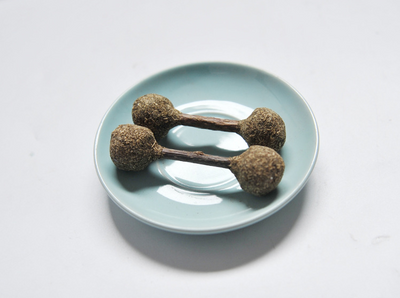 Three dumbbell-shaped catnip and silvervine chew toys with natural wood sticks on a light blue plate. - Image 9