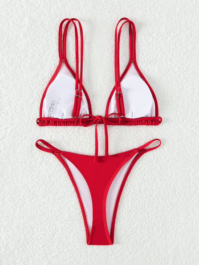 Red triangle cup halter bikini swimsuit for women on a sandy beach with ocean waves in the background. - Image 4