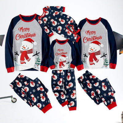 Matching family Christmas pajamas with dark blue long-sleeve tops, light gray fronts, and a snowman graphic.