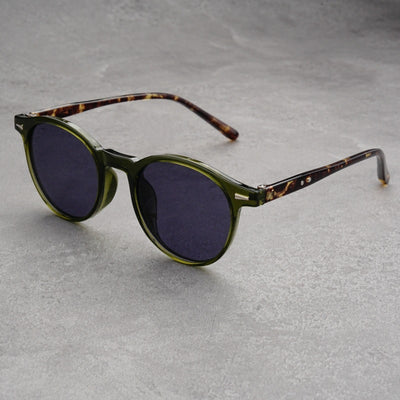 Fashionable round-frame sunglasses with transparent gray frames and dark gray lenses on a gray surface. - Image 3