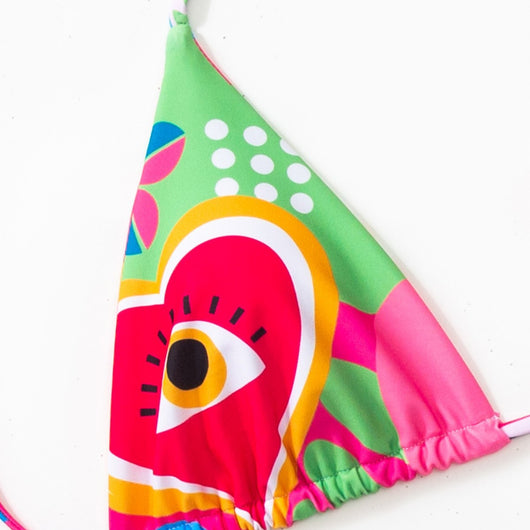 Women's vibrant abstract eye print bikini with triangle top and tie-side bottoms, featuring pink, green, and blue. - Image 3