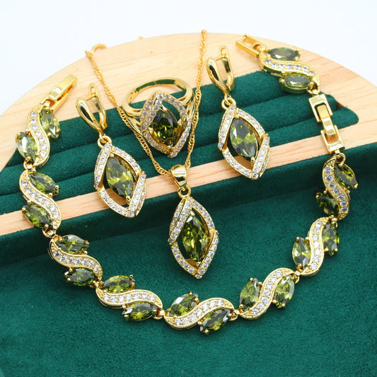 Gold-toned jewelry set with green marquise gemstones and clear accents, including a bracelet, necklace, earrings, and ring.