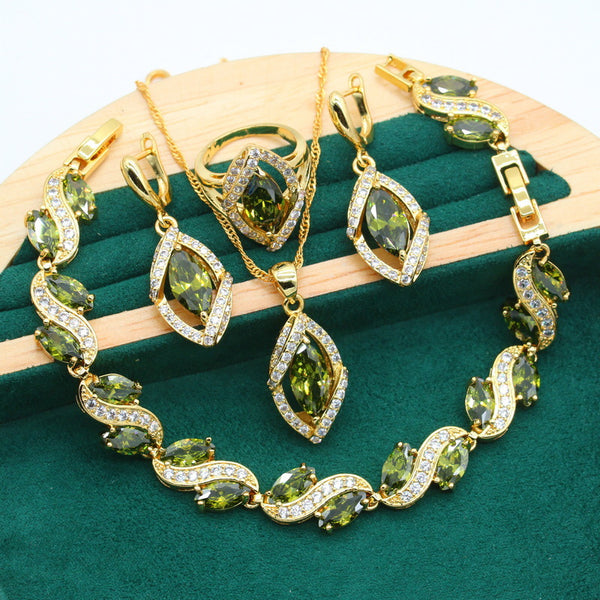 Gold-toned jewelry set with green marquise gemstones and clear accents, including a bracelet, necklace, earrings, and ring.