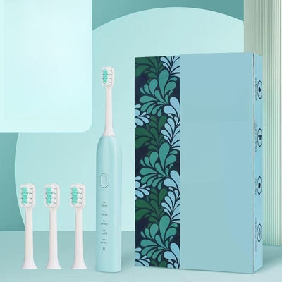 Light blue electric toothbrush with four soft bristle brush heads and a decorative box with teal leaf pattern. - Image 3