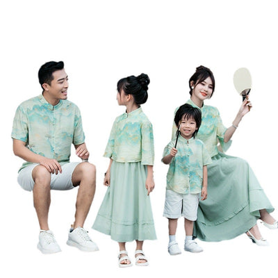 Mother and daughter in matching light green Chinese style cheongsam suits with patterned tops and solid skirts. - Image 5