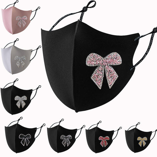 Black cloth face mask with a sparkling red and silver rhinestone bow design and adjustable ear loops.