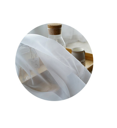 Sheer pink rod pocket curtain hanging on a black curtain rod, offering light transmission for a modern room. - Image 12