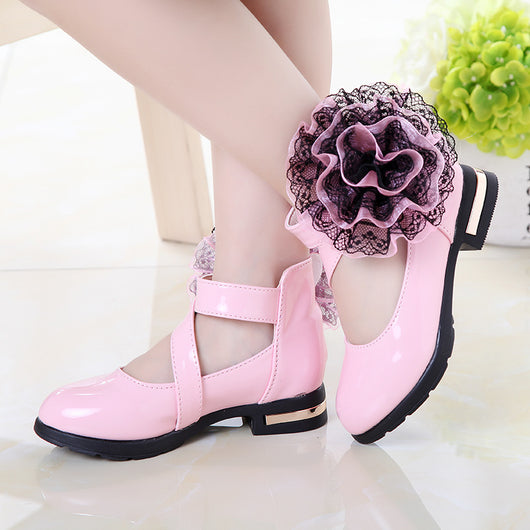 Shiny red princess shoes for little girls with a T-strap, Velcro closure, and a large red and black lace flower. - Image 3