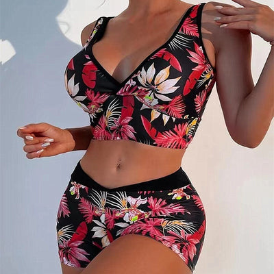 Two-piece swimsuit with a black background and vibrant pink and purple tropical floral print. Features a V-neck crop top and high-waisted boxer shorts. - Image 4