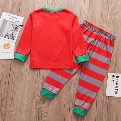 Family of five and pets wearing matching red and grey striped Christmas pajamas with Santa and penguin print. - Image 13