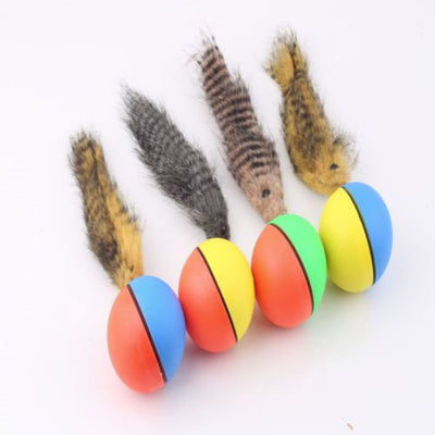 Four colorful pet toy balls with faux fur tails, in blue, yellow, orange, and green, on a white background.