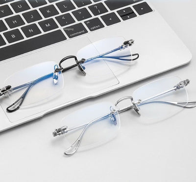 Silver rimless reading glasses with clear lenses held by a hand, featuring decorative temples and smart zoom technology. - Image 6