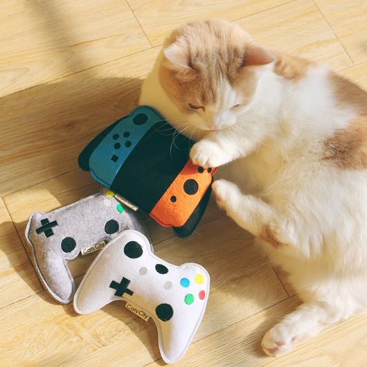 Light blue felt catnip toy shaped like a game controller with piano keys and a black string for hanging. - Image 16