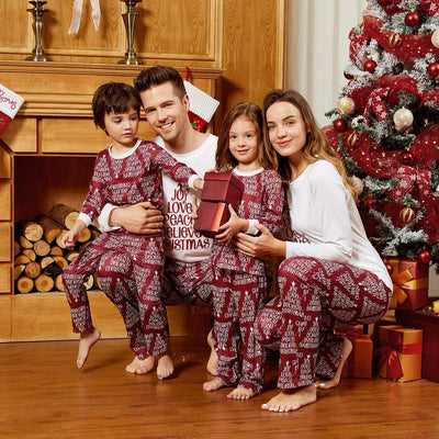 Family of four in matching Christmas pajamas: white tops with red tree graphic, red bottoms with white text. - Image 6