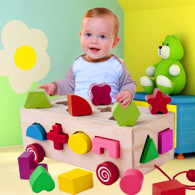 Happy baby playing with a wooden shape matching building block toy, featuring a natural wood box and colorful geometric shapes.