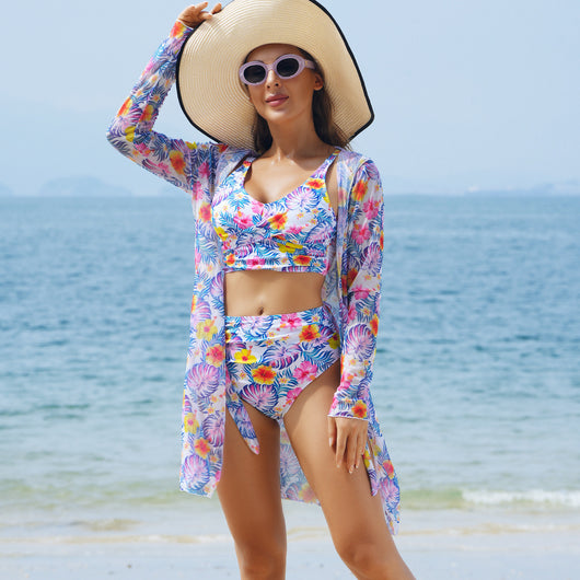 Woman in a red multicolor floral print three-piece swimsuit with high-waisted bikini and long-sleeve cover-up, straw hat, and sunglasses on a beach. - Image 9