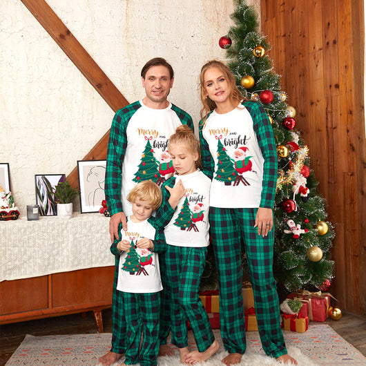 Men's Christmas pajama set with a white top featuring a Santa and Christmas tree graphic, and green plaid pants.