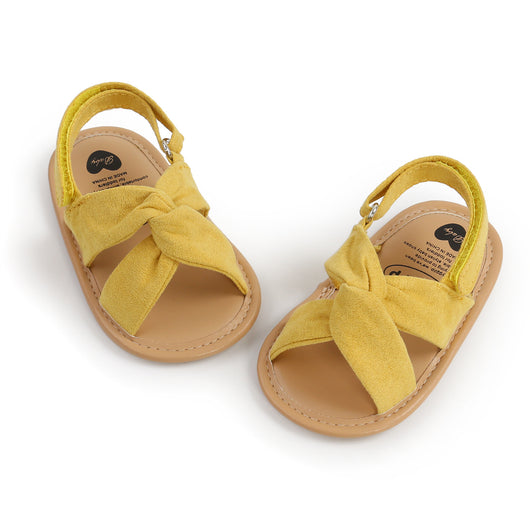 Black baby sandals with knotted cross straps and a matching black floral headband on a white background. - Image 18