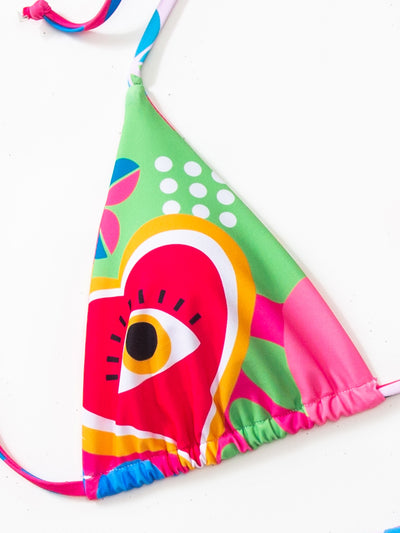 Women's vibrant abstract eye print bikini with triangle top and tie-side bottoms, featuring pink, green, and blue. - Image 10