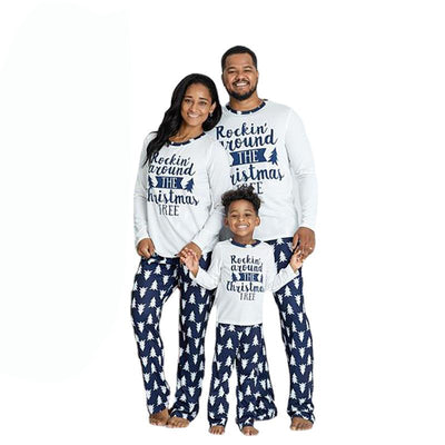 Family of three wearing matching white and navy blue Christmas pajamas with "Rockin' around THE Christmas TREE" text.