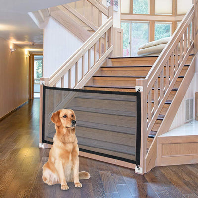 Black mesh pet gate installed at the bottom of a wooden staircase, with a golden retriever sitting in front. - Image 4