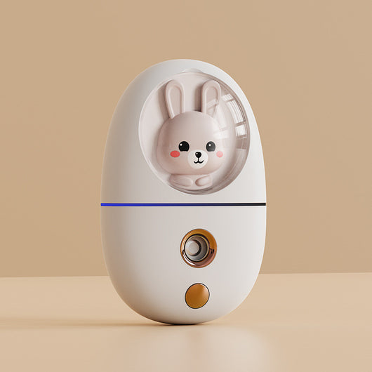 White egg-shaped portable facial humidifier with a pink cartoon rabbit inside a clear dome, gold nozzle and button. - Image 15
