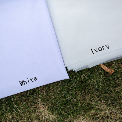 White and ivory sheer fabric swatches for a wedding veil displayed on green grass. - Image 6