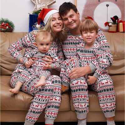 Family of four wearing matching white, red, and green fair isle Christmas pajamas with reindeer and snowflake patterns. - Image 3