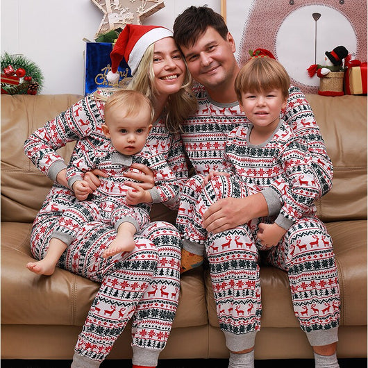 Family of four wearing matching white, red, and green fair isle Christmas pajamas with reindeer and snowflake patterns. - Image 3