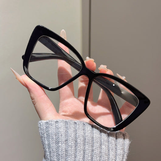 Clear large-frame square glasses held by a hand in a grey knitted sweater, showcasing the transparent plastic frame. - Image 13