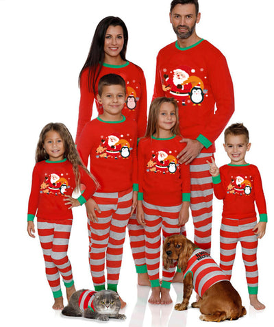 Family of five and pets wearing matching red and grey striped Christmas pajamas with Santa and penguin print. - Image 12