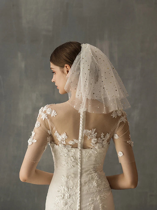 White multi-layer short bridal veil with gold star embellishments, worn by a model in a white lace wedding dress. - Image 11