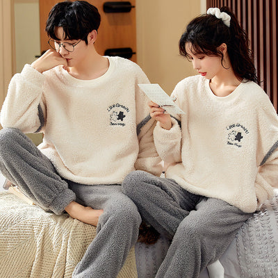 Couple wearing matching cream coral fleece pajamas with gray pants and bear embroidery, seated on a bed. - Image 8