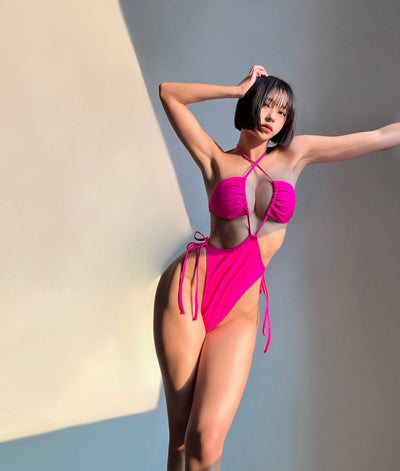 Black drawstring one-piece swimsuit with a ruched halter top and high-cut, tie-side bottom on a woman. - Image 15