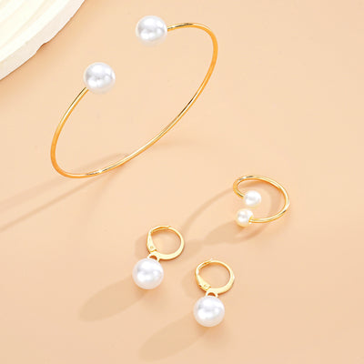 Gold-tone open cuff bracelet, matching open ring, and dangle earrings, all featuring white faux pearls. - Image 8