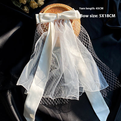 White birdcage veil with a cream satin bow and faux pearls, attached to a woven straw base, 80cm yarn length. - Image 24